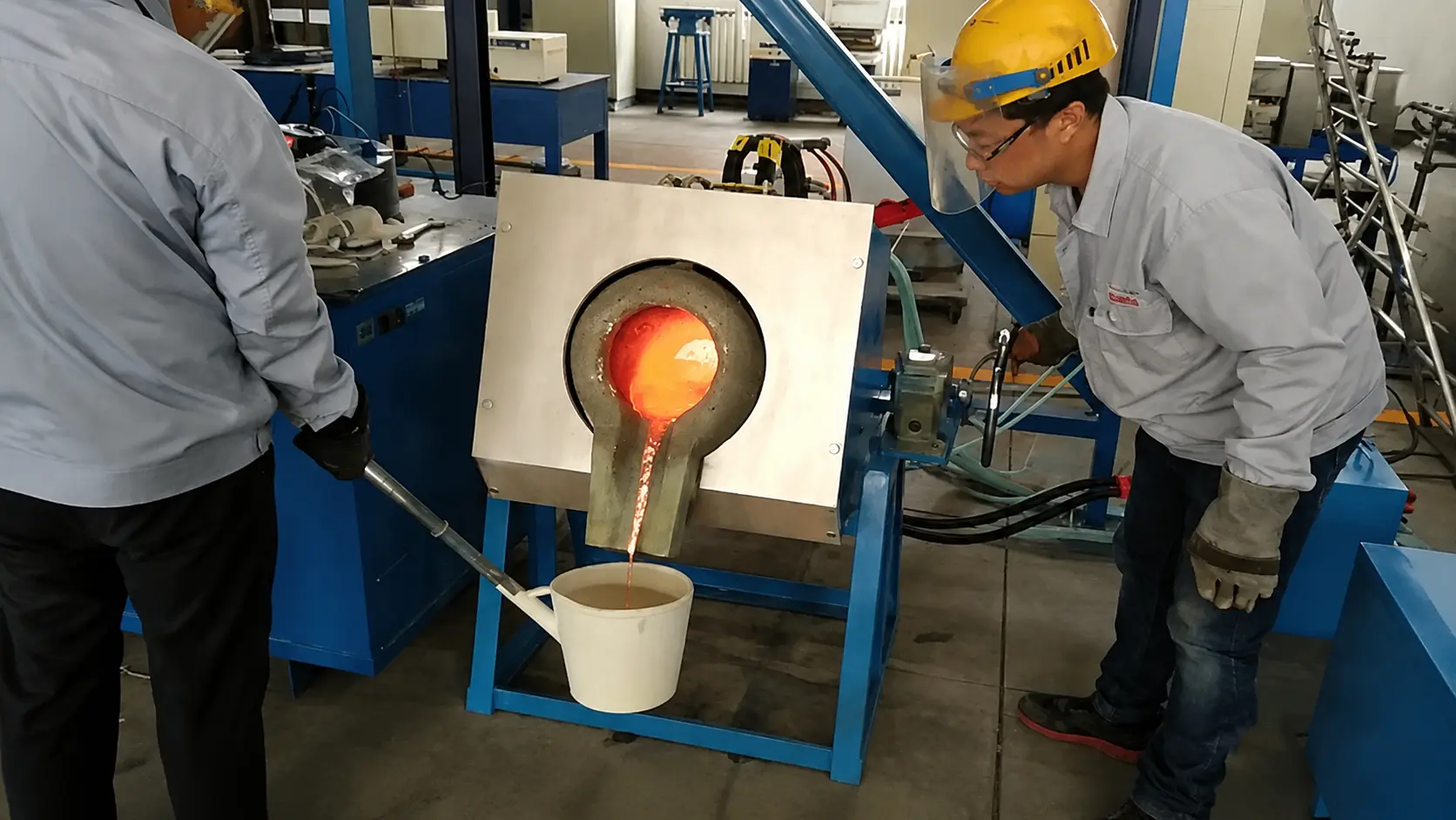 Ist Induktionserwärmung sicher?sichGrundlegende Sicherheitsfaktent SicheBest Practices für Bedienerige Handschuhe und bedient eine Induktionserwärmungsmaschine mit glühendem Metallwerkstück in der Spule is induction heating safe — operator wearing safety helmet and heat-resistant gloves operating induction heating machine with glowing metal workpiece in coil