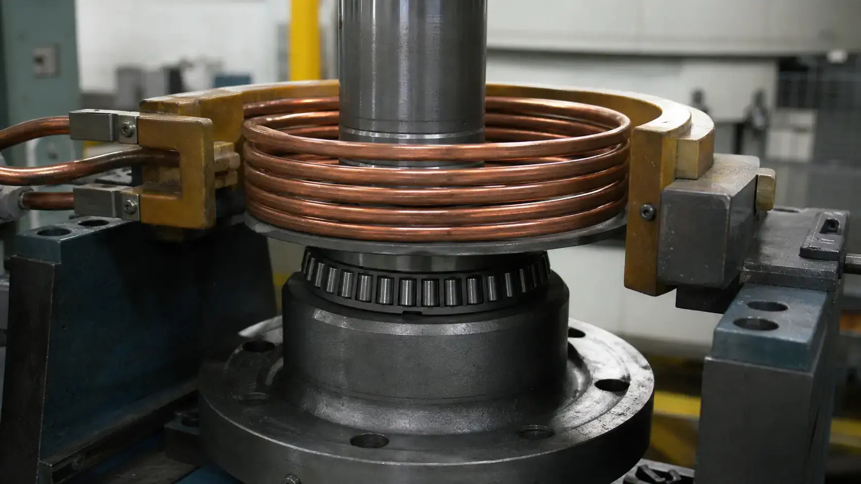 Prima di acquistare una macchina per montaggio a caldo a induzionee, bDecisioni importantinata attorno a un albero d'acciaio con sistema industriale Induction shrink fitting machine copper coil positioned around a steel shaft with industrial fixturing